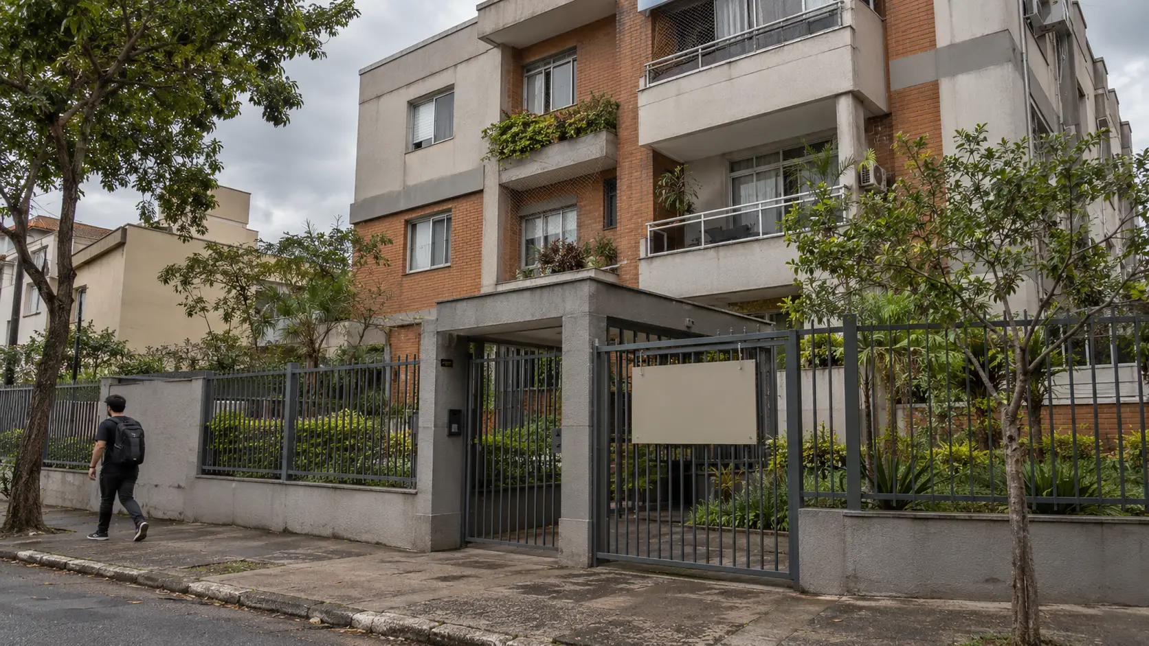 Prédio residencial antigo numa rua arborizada, em dia nublado