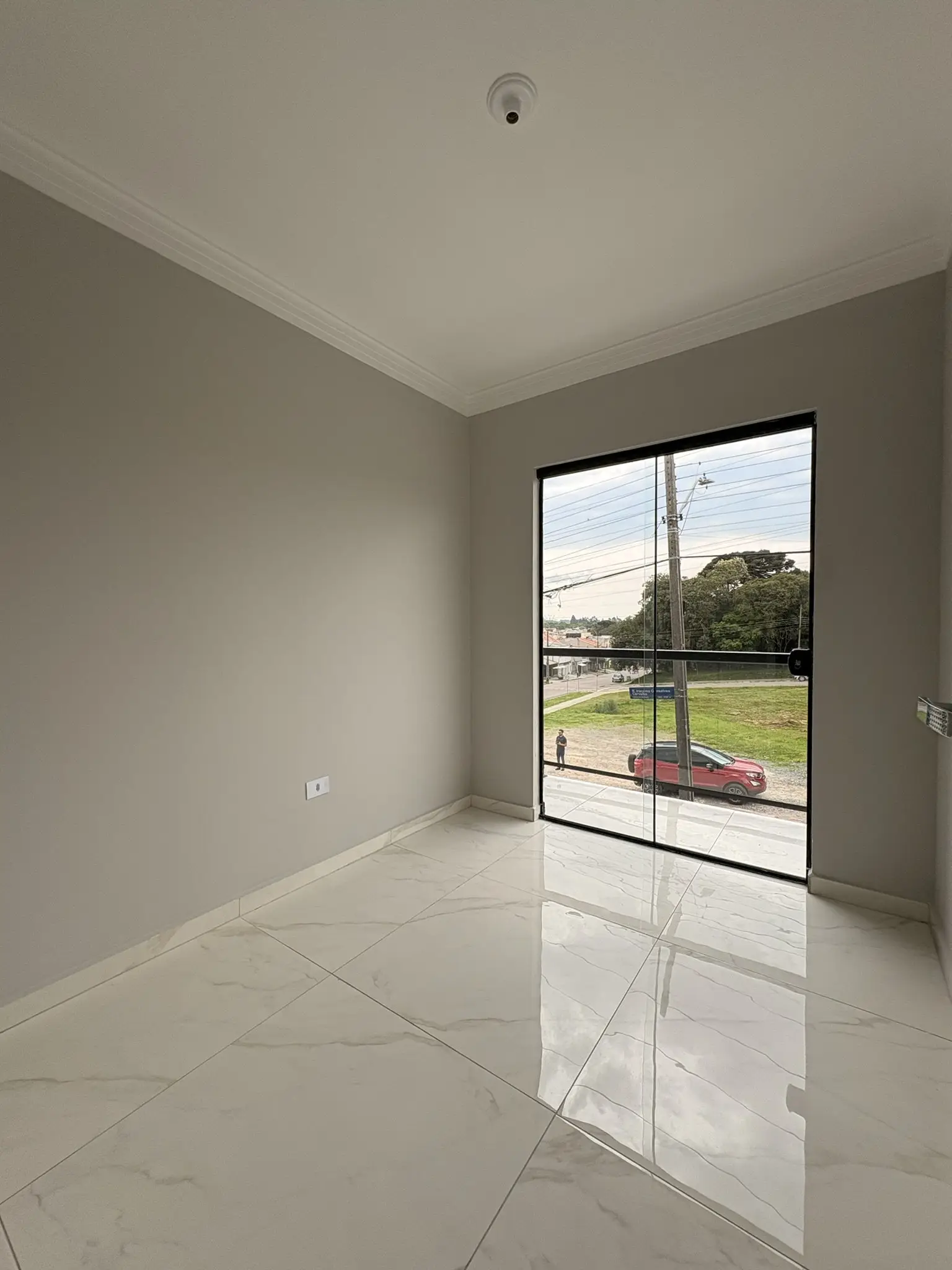 Sala com piso porcelanato e porta de vidro